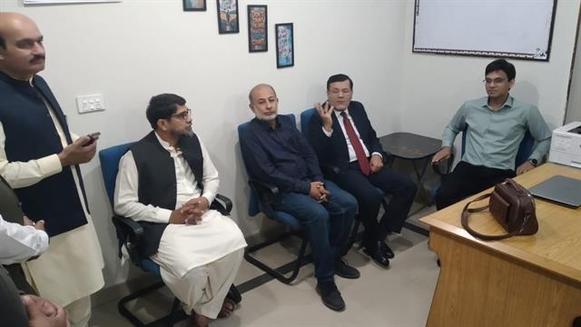 The Director meeting faculty members in a department room