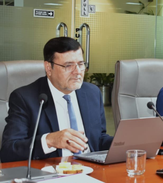A participant at the conference table during the proceedings