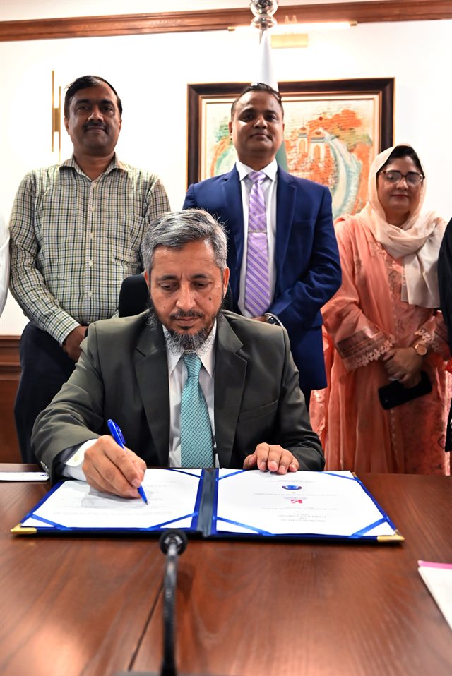 The memorandum of understanding being signed at the boardroom table