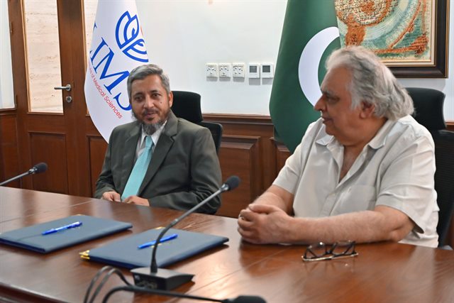 The two signatories seated at the table before the signing ceremony