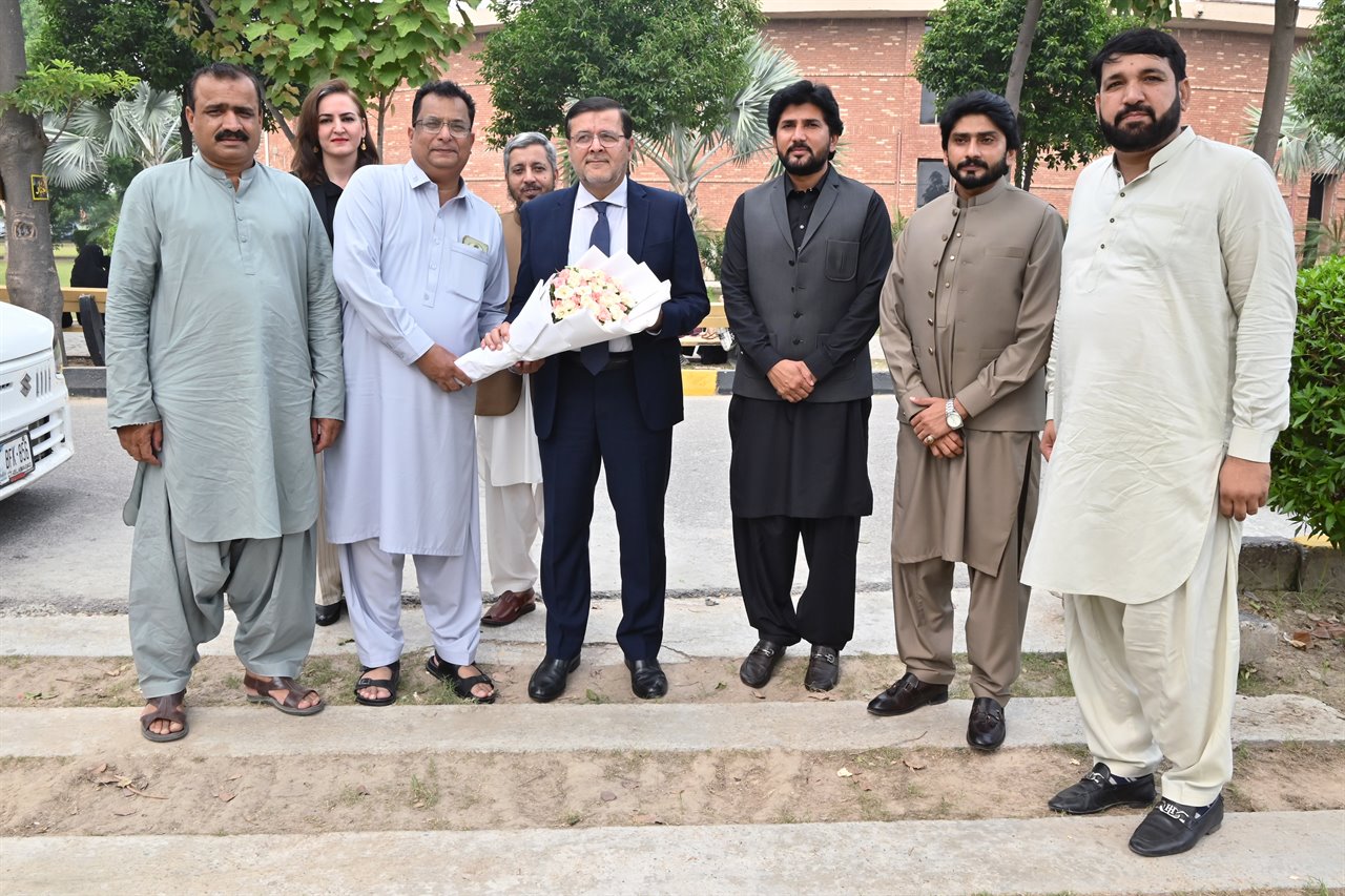 A group photograph with a bouquet presented to the Director