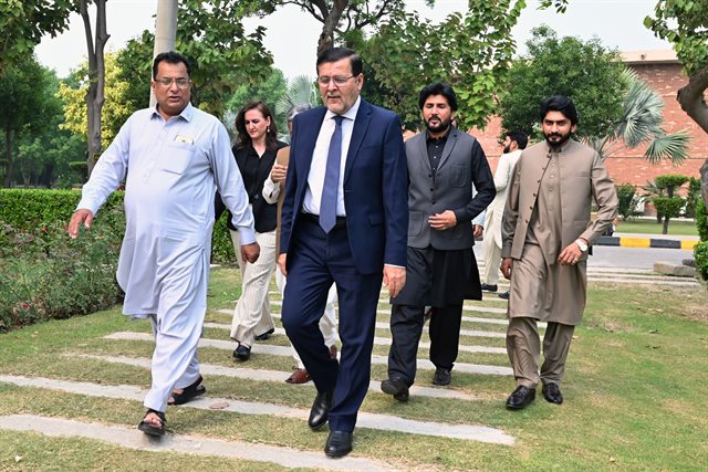 Prof. Dr. Qaisar Abbas walking across the CUI Lahore campus with colleagues