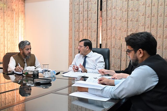 A discussion at the Director's desk