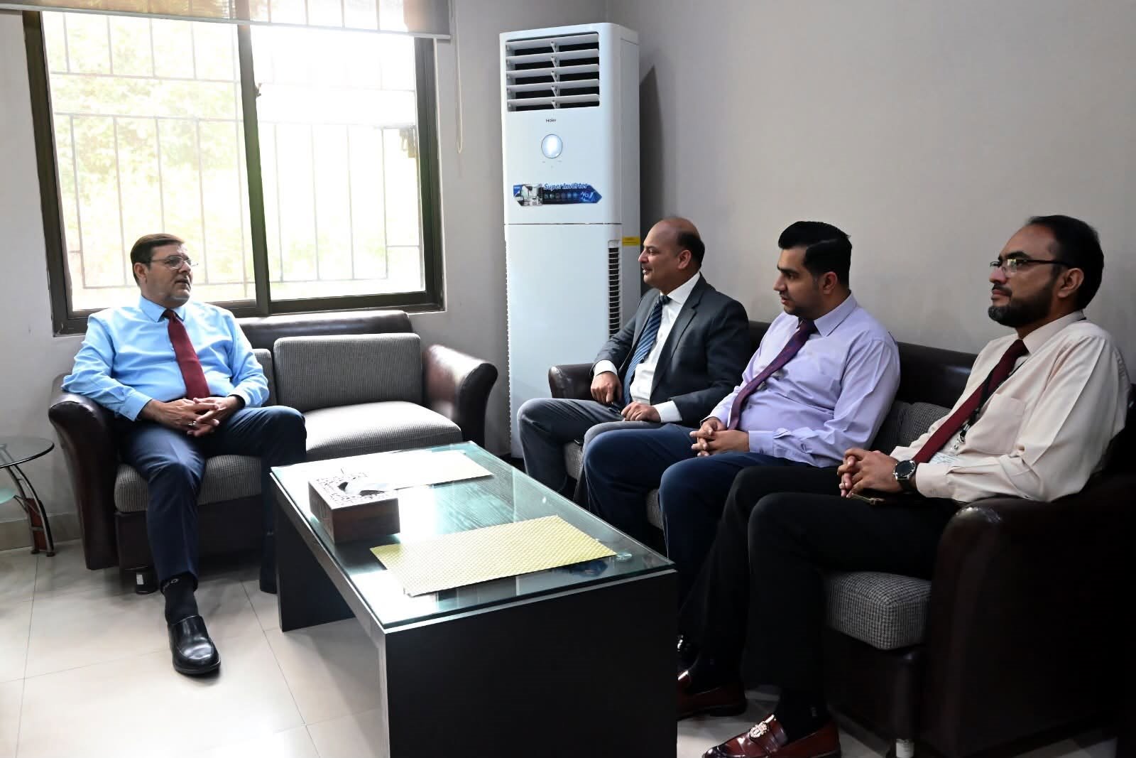 A visiting delegation seated with the Director at the Director Secretariat