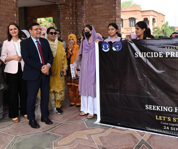 The Director with participants behind the Suicide Prevention Awareness Walk banner