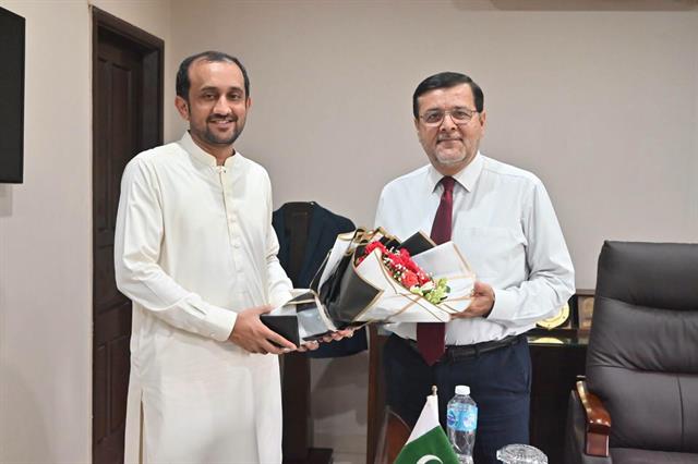 A guest presenting a bouquet and a gift to the Director