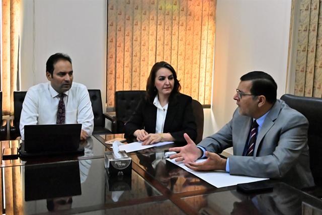 The Director in discussion with faculty members at the boardroom table