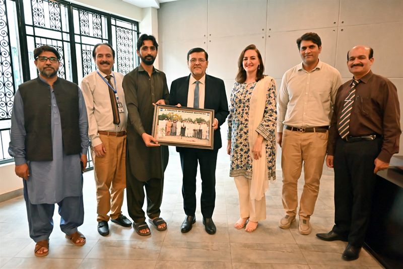 The Director holding the framed photograph with colleagues