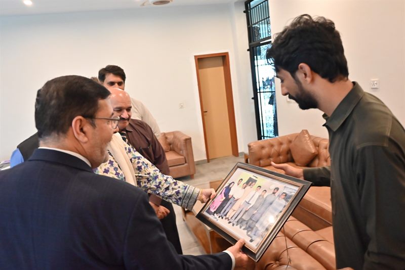 A framed photograph being presented to the Director