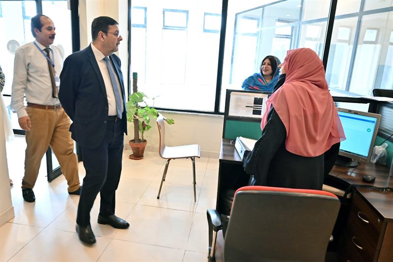 The Director speaking with staff at a service desk