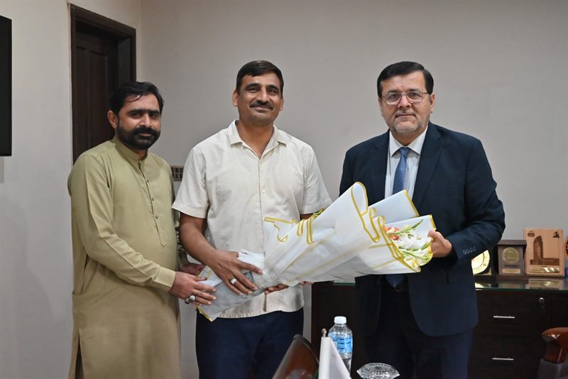 Two guests presenting a bouquet to the Director at the Directorate