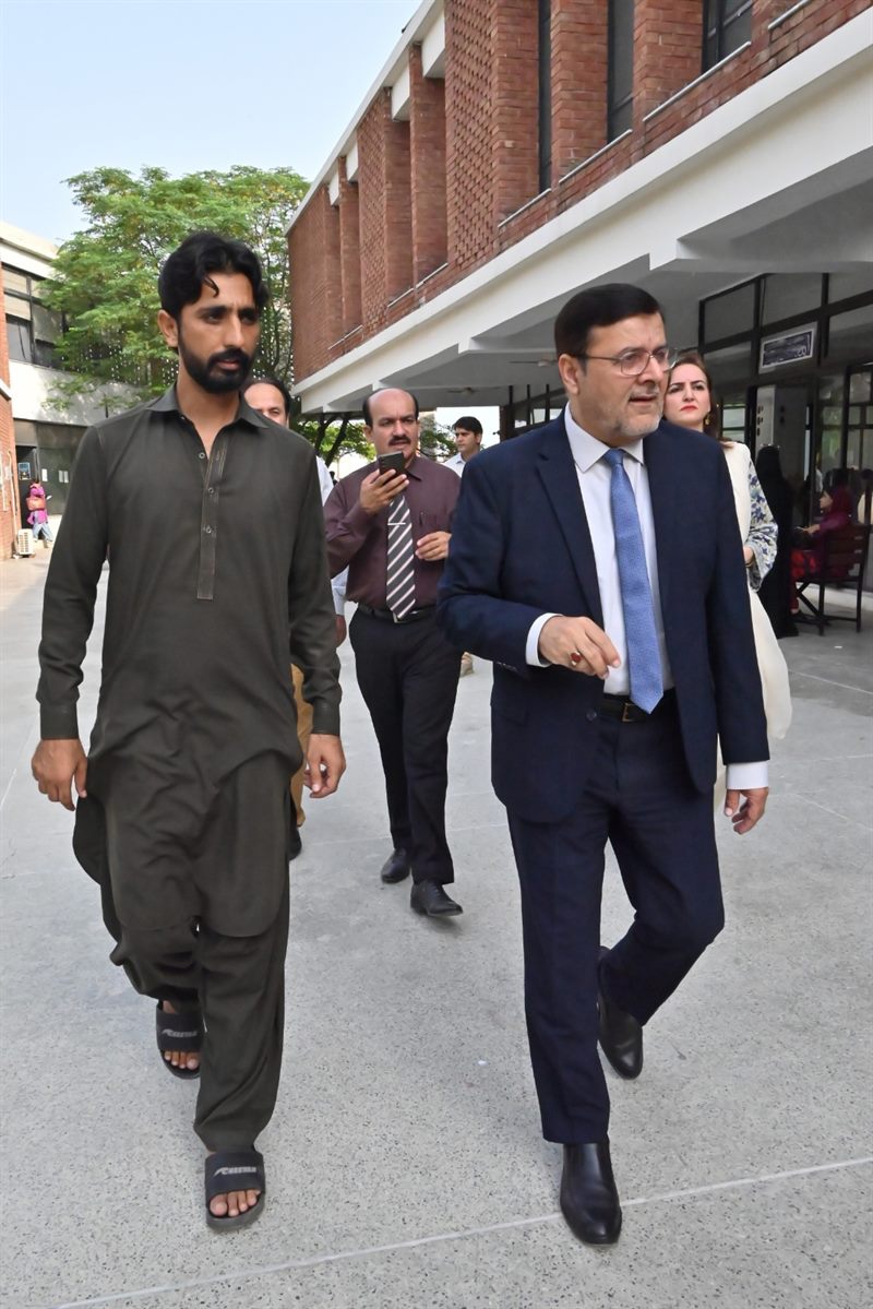 The Director walking through the campus alongside a student