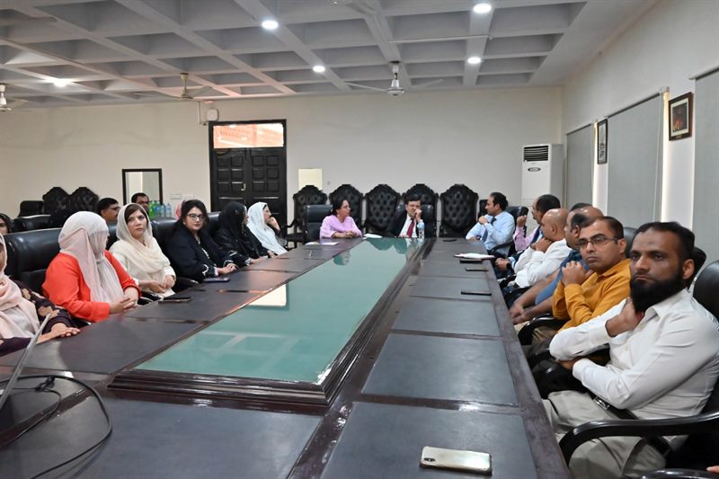 Wide view of faculty members seated along the conference table during the meeting
