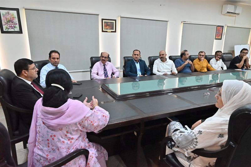 The Director in discussion with faculty members at the conference table