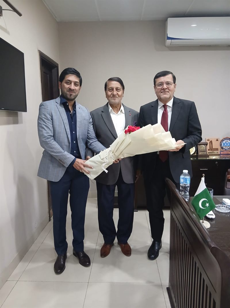 Guests presenting a bouquet to the Director in his office