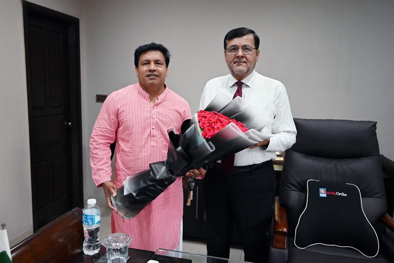A guest presenting a bouquet to the Director in his office