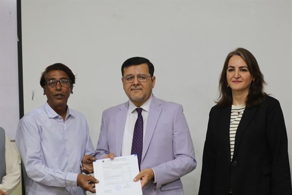 A staff member receiving a promotion letter from the Director