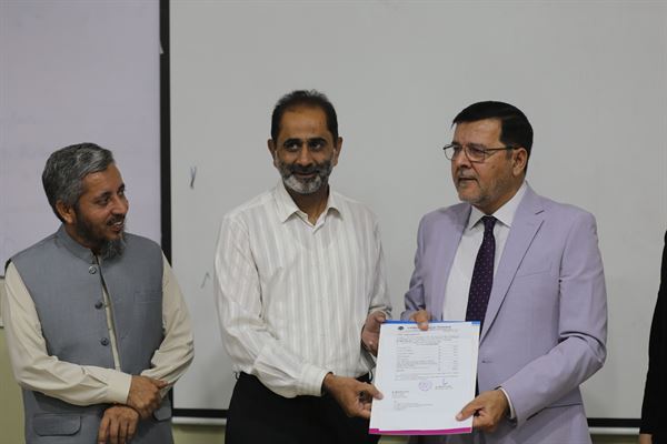 A promotion letter being presented to a member of staff by colleagues