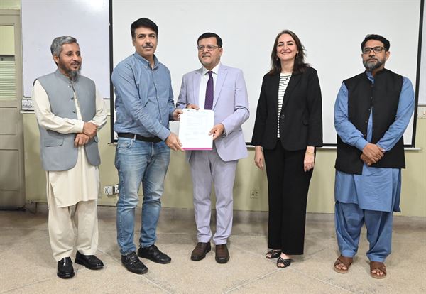 A member of staff receiving his promotion letter, with senior officials of the Campus present